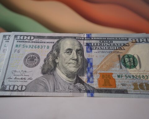 a stack of one hundred dollar bills sitting on top of a table