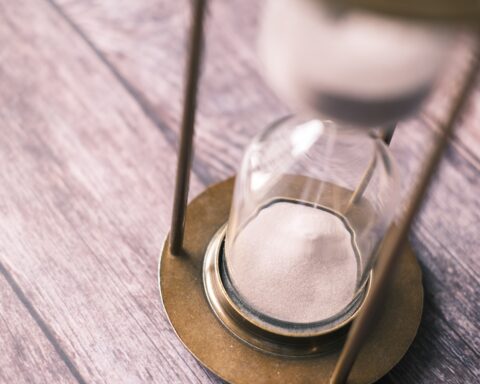 an hourglass sitting on top of a wooden table
