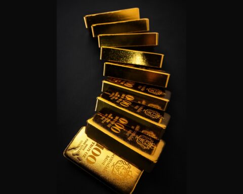 Stacked gold bullion bars on a dark background