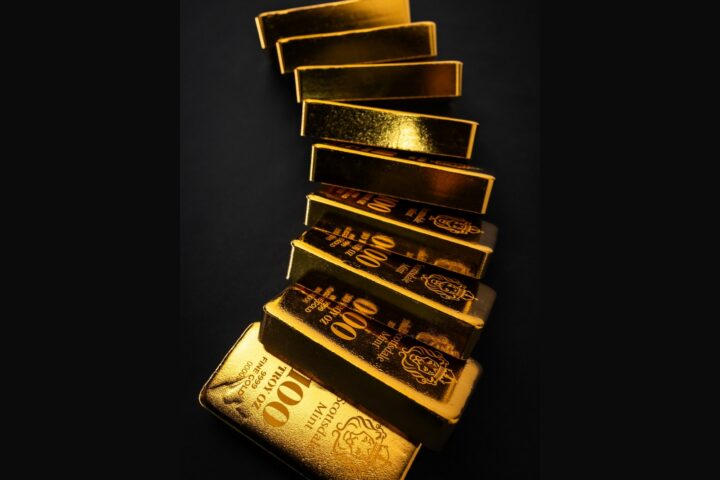 Stacked gold bullion bars on a dark background